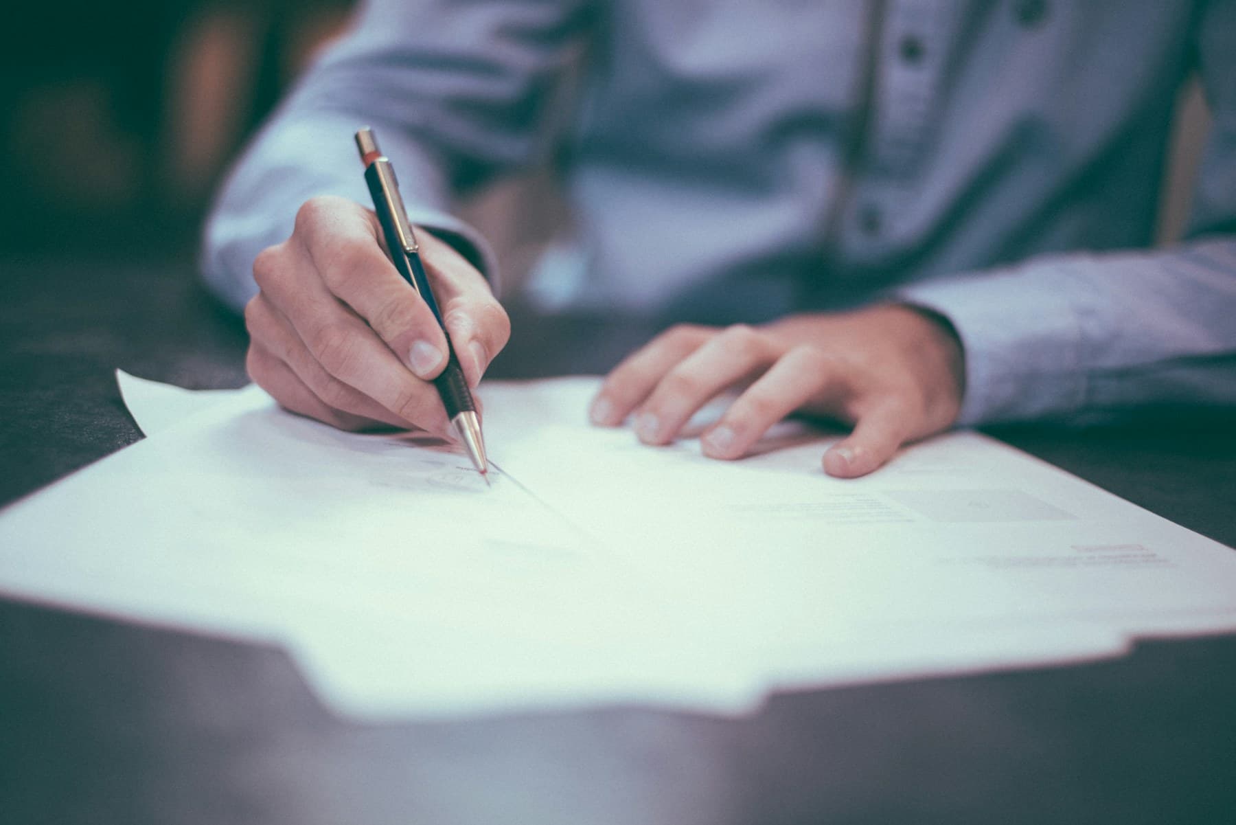 Vertragsunterlagen, Stift und Notizen auf einem ruhigen Tisch